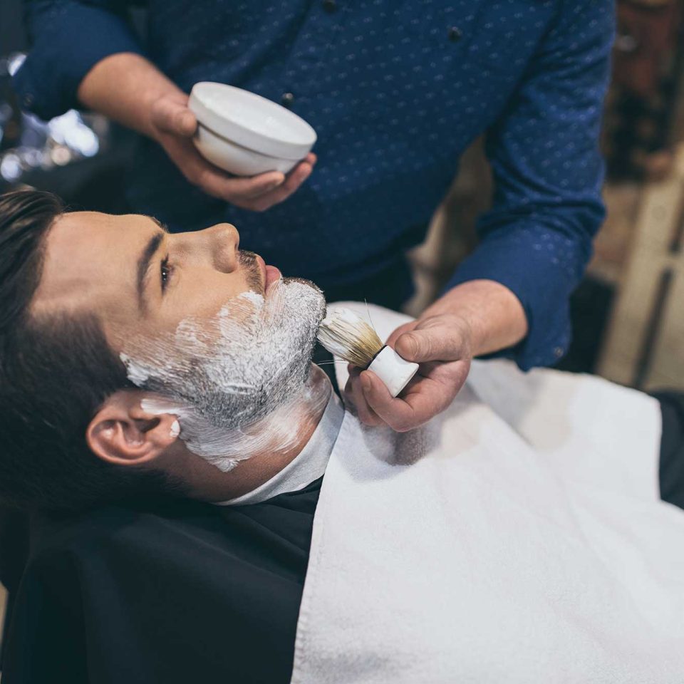 barber-applying-foam-before-shaving-of-customer-in-2022-12-16-17-03-17-utc-2.jpg